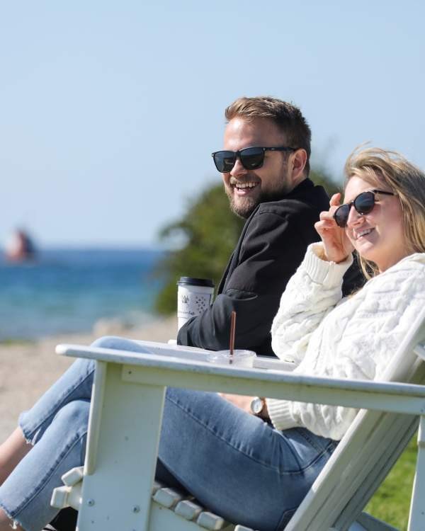 Couple enjoying a beach on Mackinac Island with the Mackinac Bridge in the background
