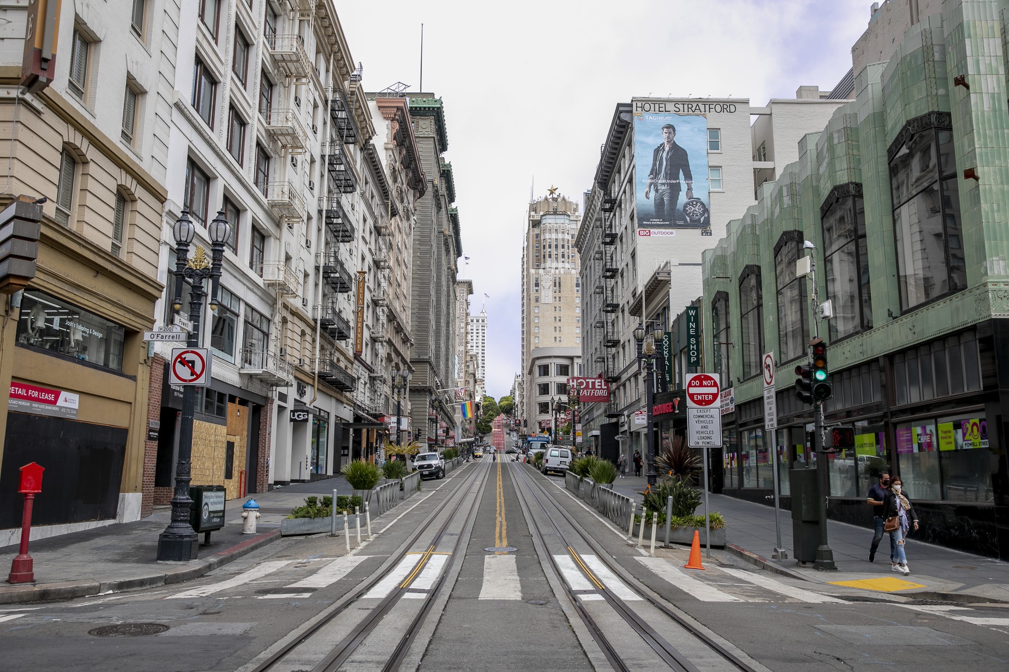 Pedestrians walk past vacant store fronts along Powell Street in the Union Square shopping district in San Francisco, showcasing the economic impact on local businesses during the pandemic