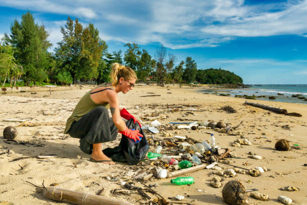 Environmental cleanup one woman Koh Lanta beach Thailand
