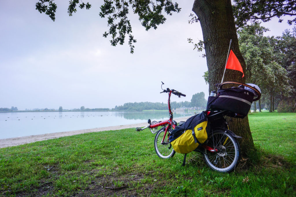 A recumbent touring bike leaning against a tree in the Netherlands.