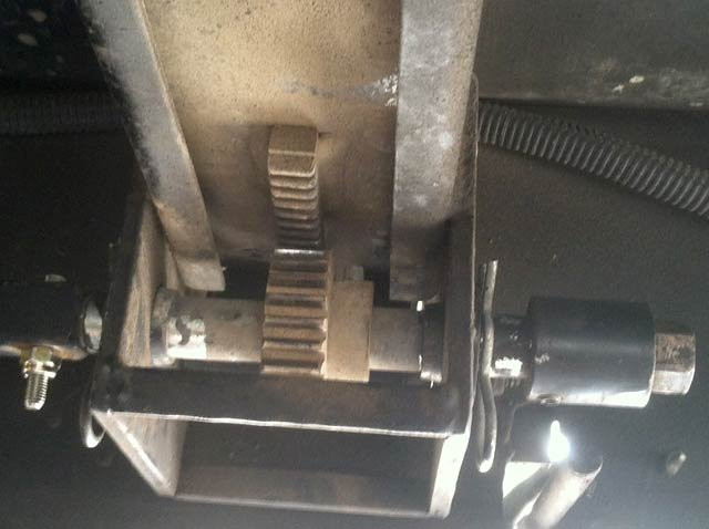 Idler rail with gear in functioning position.The photo above shows the idler rail, or slave rail with gear engaged in the normal operating position and cotter pin attached. It is not necessary to remove the drive shaft from the gear (retainer bolt shown at left).