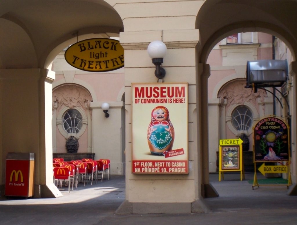A sign for the old Communism Museum in Prague, Czech Republic depicts a Russian doll with fangs next to a Mcdonalds