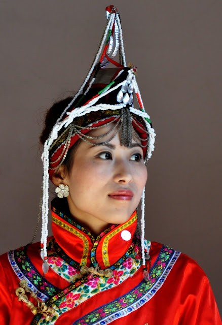 Close-up of a She woman in traditional attire, highlighting the intricate hair arrangements and traditional clothing that reflect the unique cultural identity of the She people.