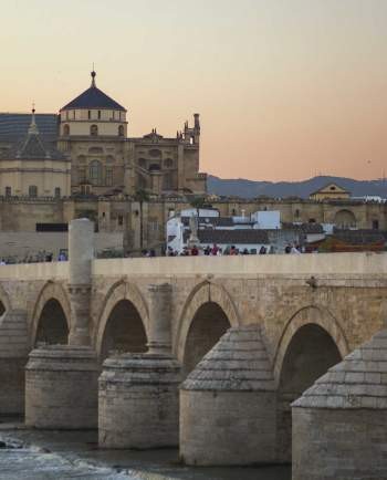 Puente Romano and Mezquita de Cordoba alt text: The mesmerizing scene of Puente Romano and Mezquita de Cordoba capturing Andalusia tourism and iconic historical monuments