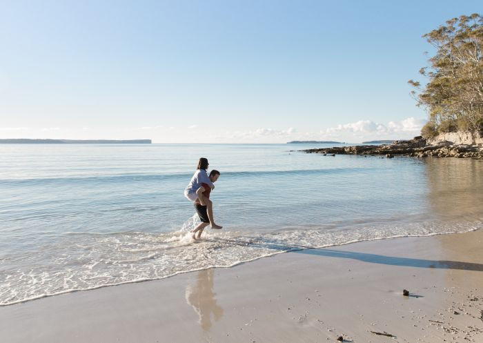 Couple relaxing on the pristine sands of Blenheim Beach, Jervis Bay