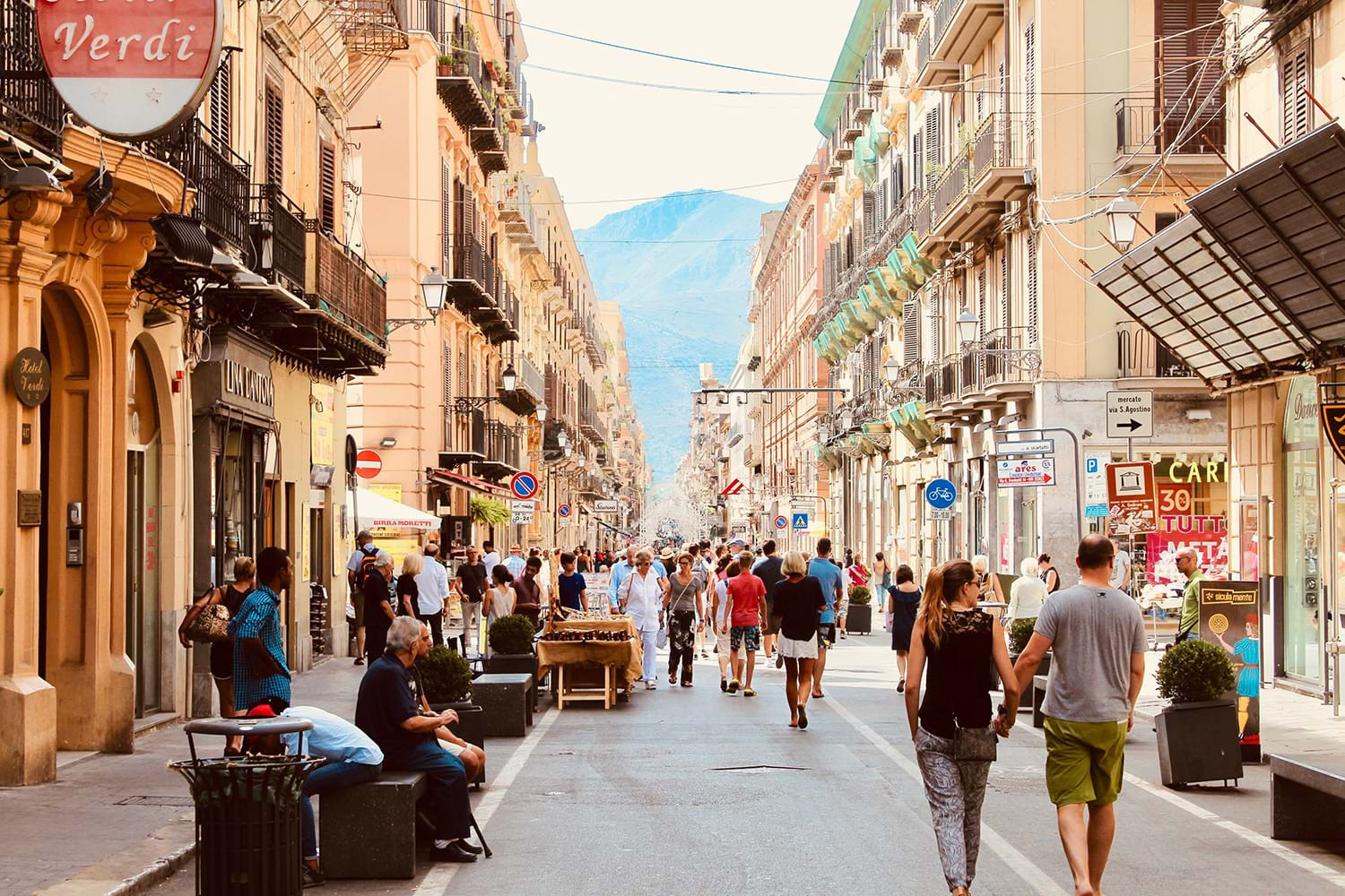 Travelers navigating a bustling European street with luggage