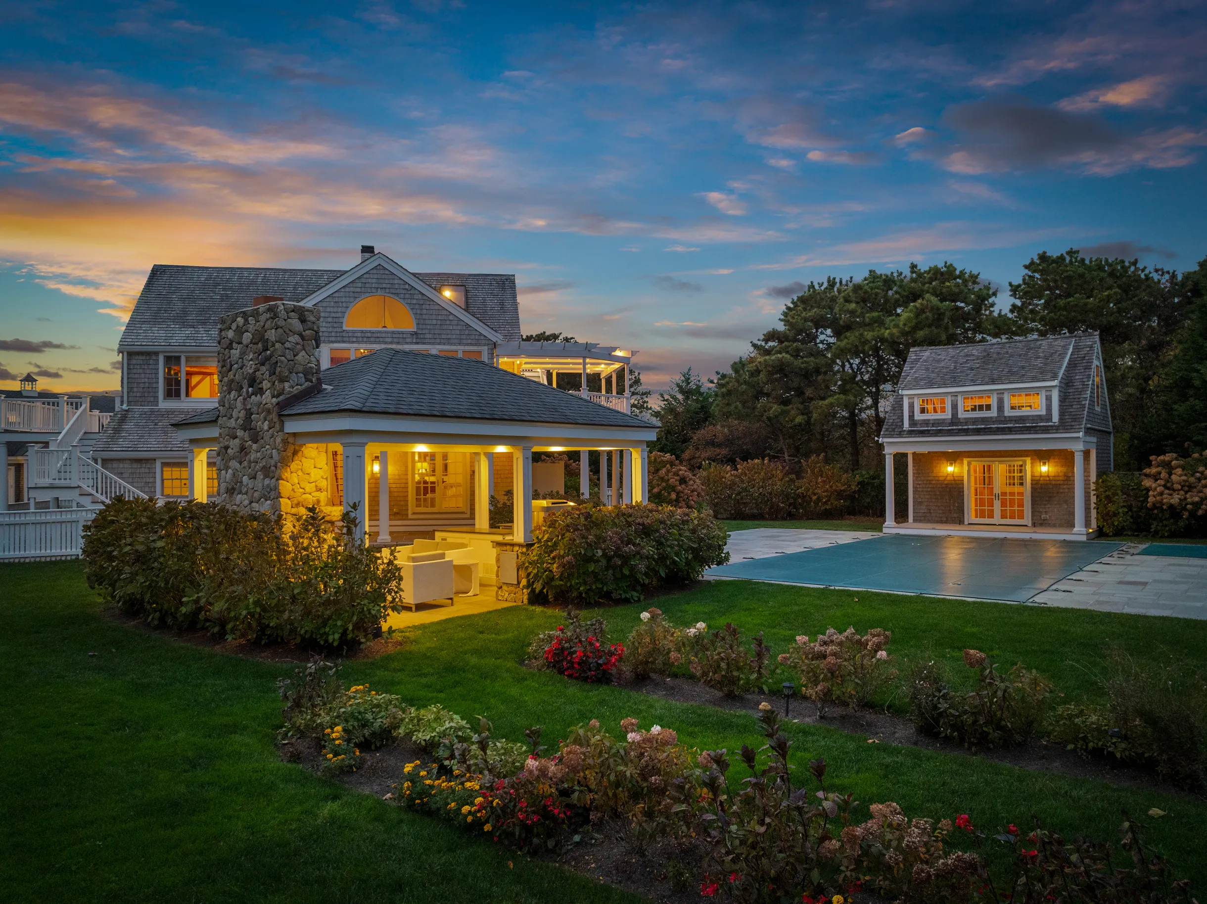 A property in Martha's Vineyard with grey houses, a pool, and a garden