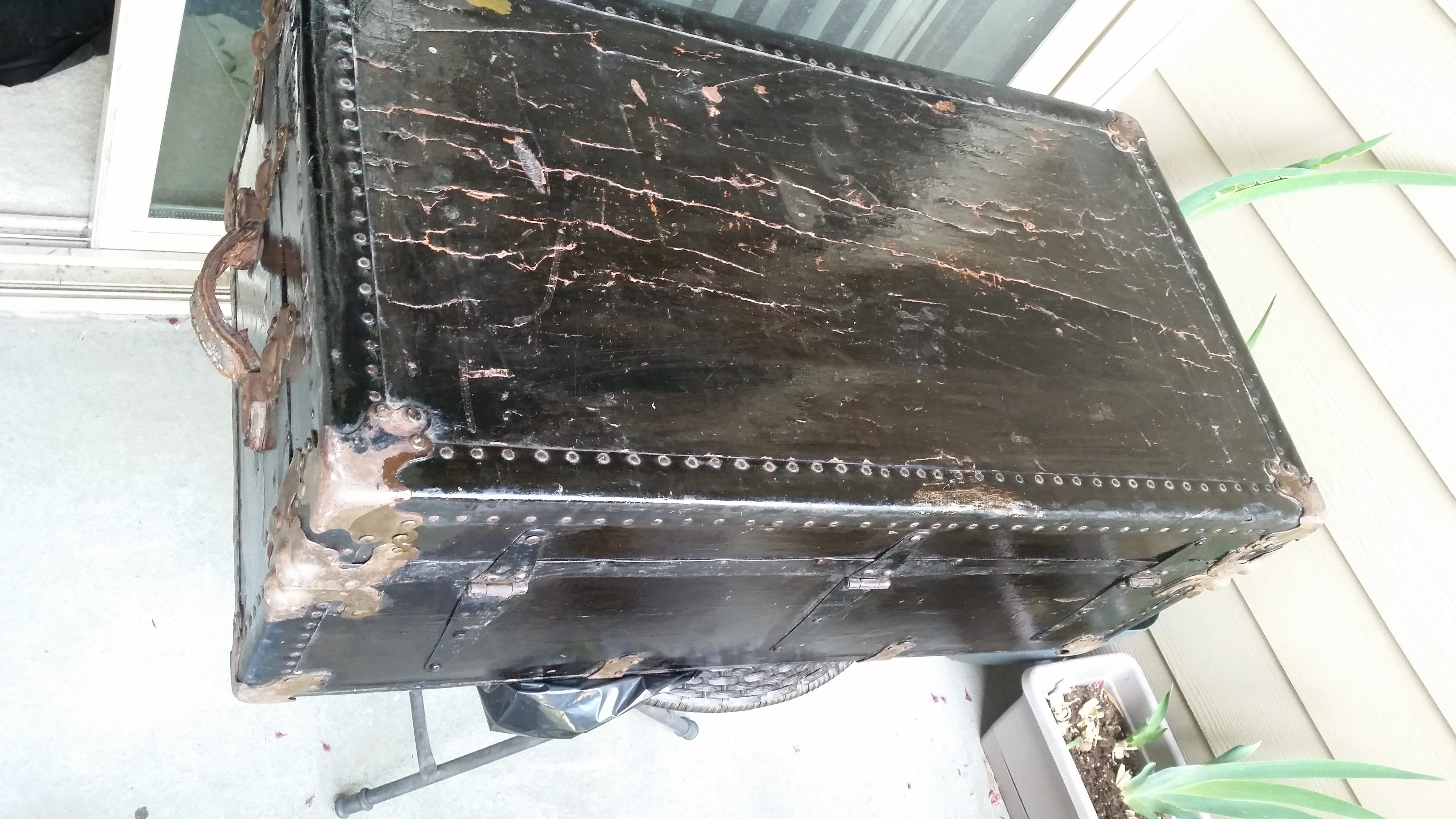 Antique steamer trunk after leather conditioning, showing the before and after effect