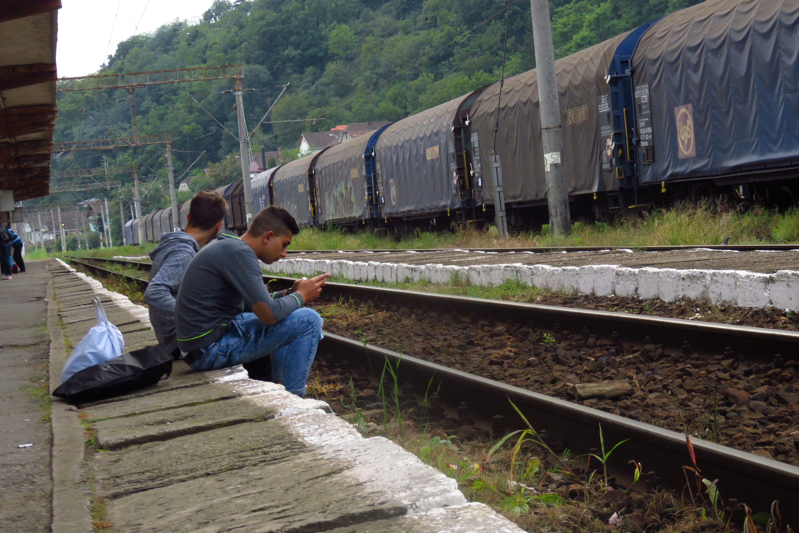 Boys dangling their legs at Sighisoara station, Romania