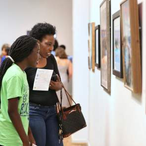 Two people looking at art hanging on the wall at Mobile Museum of Art Alabama
