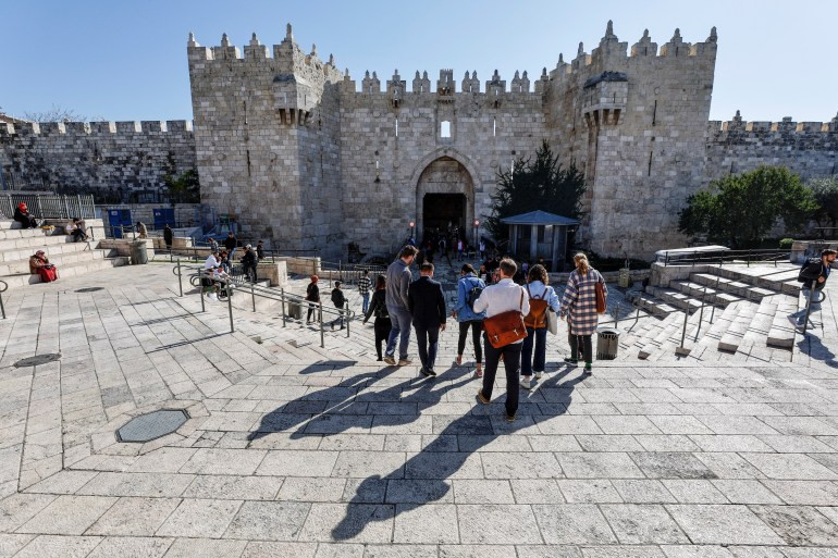 Tourists walk in the Old City of Jerusalem amidst the ongoing Israel-Hamas conflict, reflecting the resilience of the region