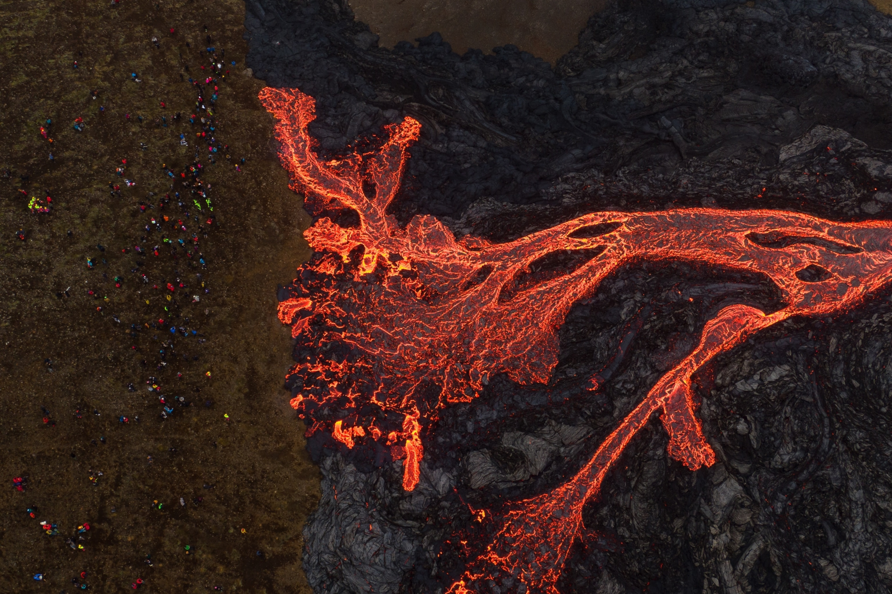 Aerial view of tourists observing lava flow