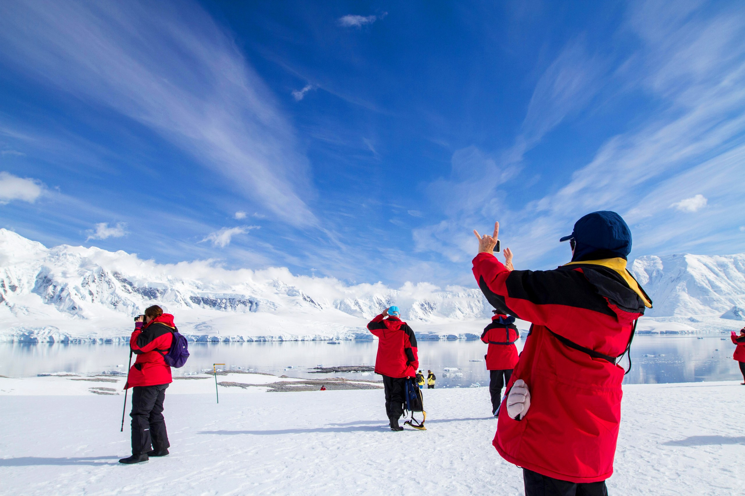 People on an expedition in Antarctica, featuring icy landscapes and penguins