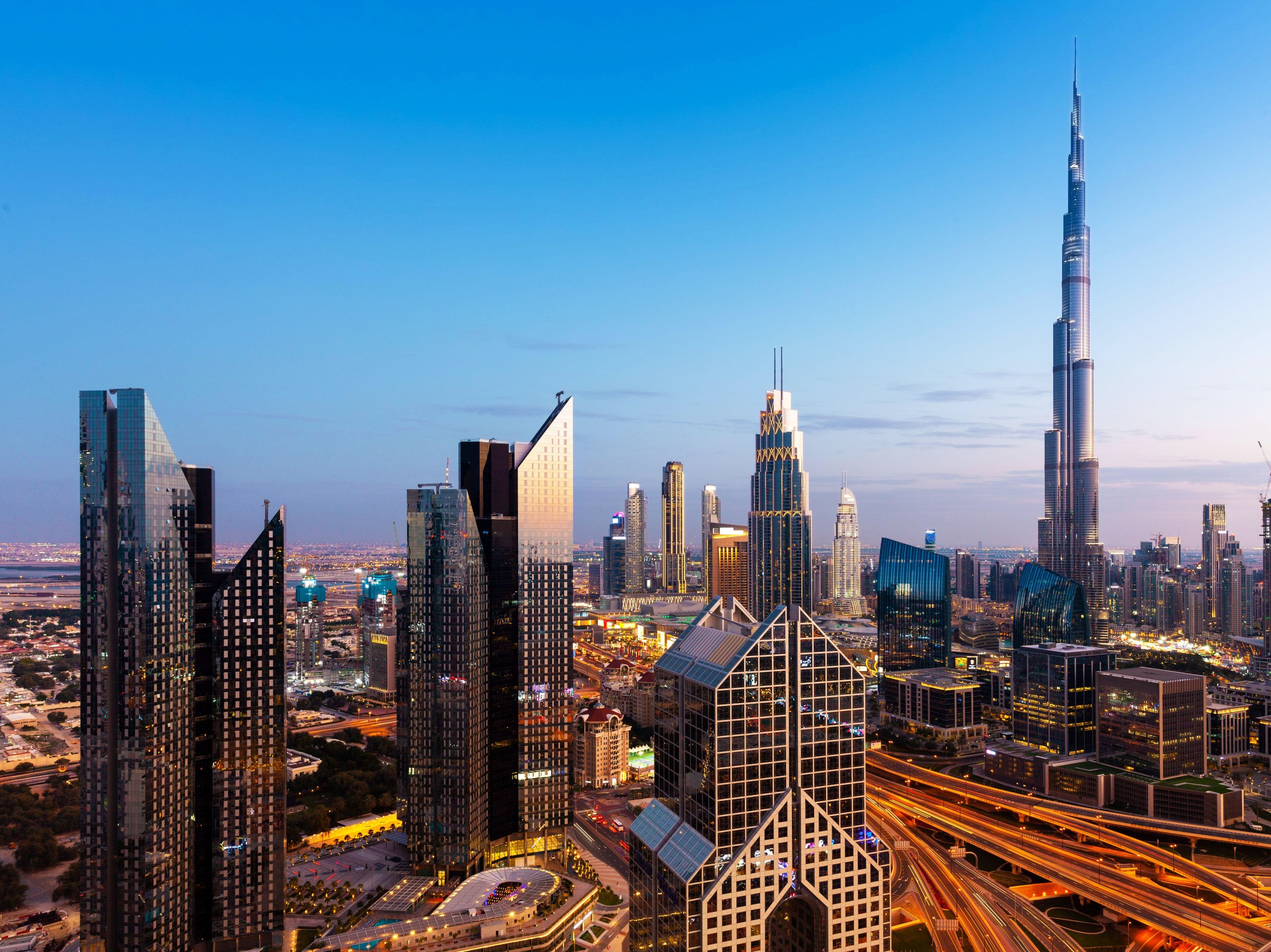 The Dubai skyline at dusk, showcasing illuminated skyscrapers and a vibrant urban landscape