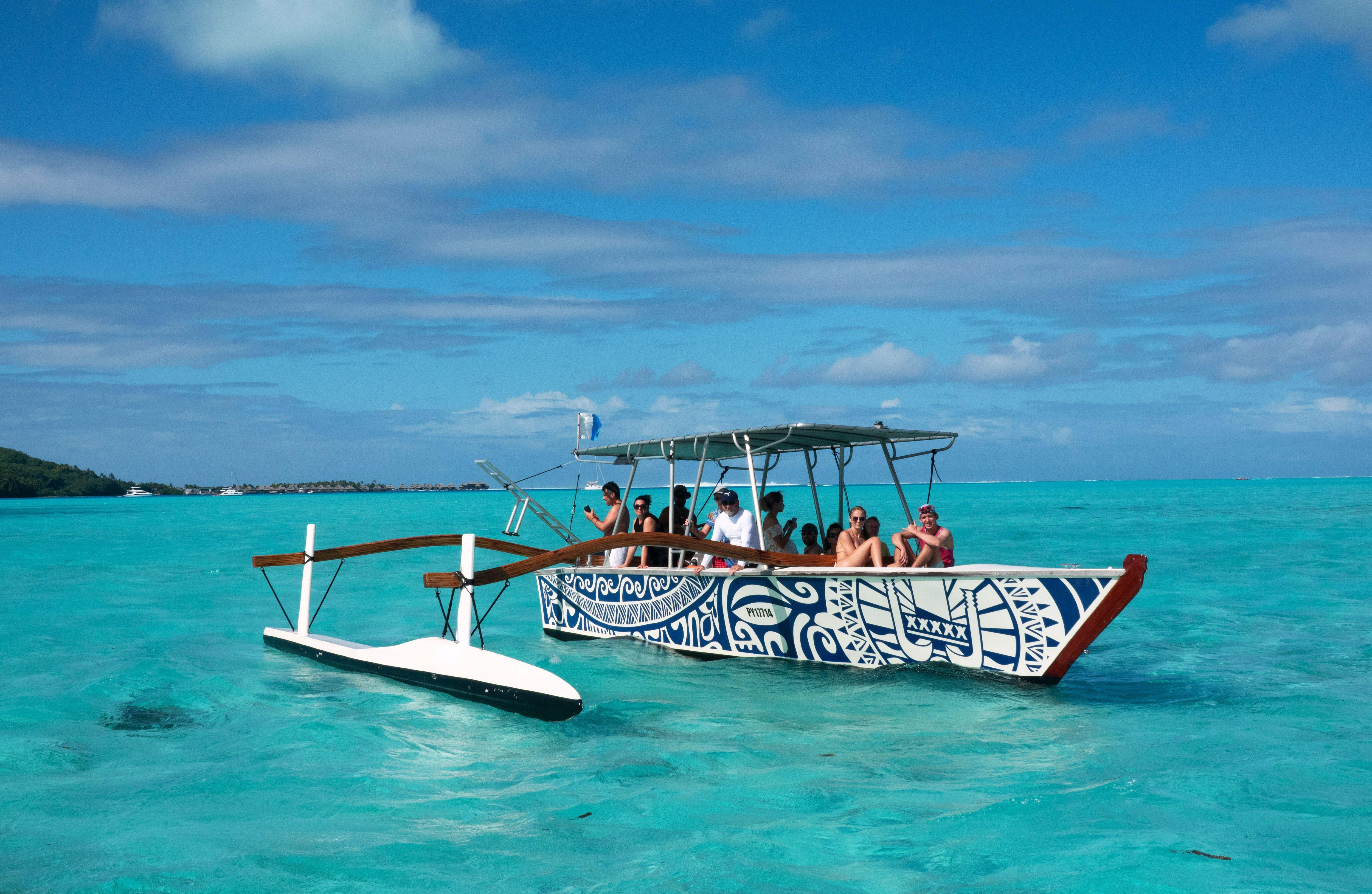 A Polynesian canoe tour in Bora Bora, featuring clear blue waters and lush green mountains