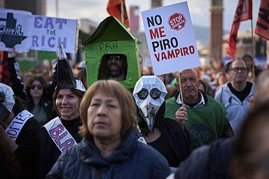 People gather during a demonstration to protest high housing costs in Barcelona, Spain, Saturday, April 5, 2025. The sign says