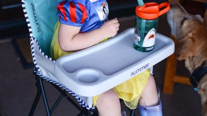 picnic in a park with a baby in a travel highchair