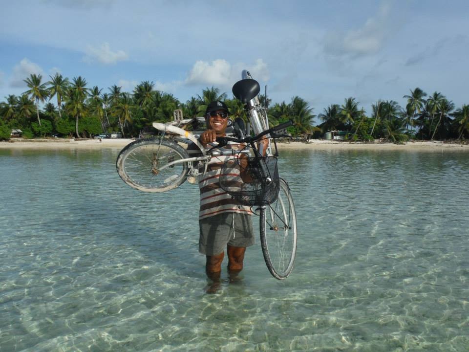 A traditional Kiribati outrigger canoe sailing on clear turquoise waters, showcasing the local maritime culture and the natural beauty of the island nation.
