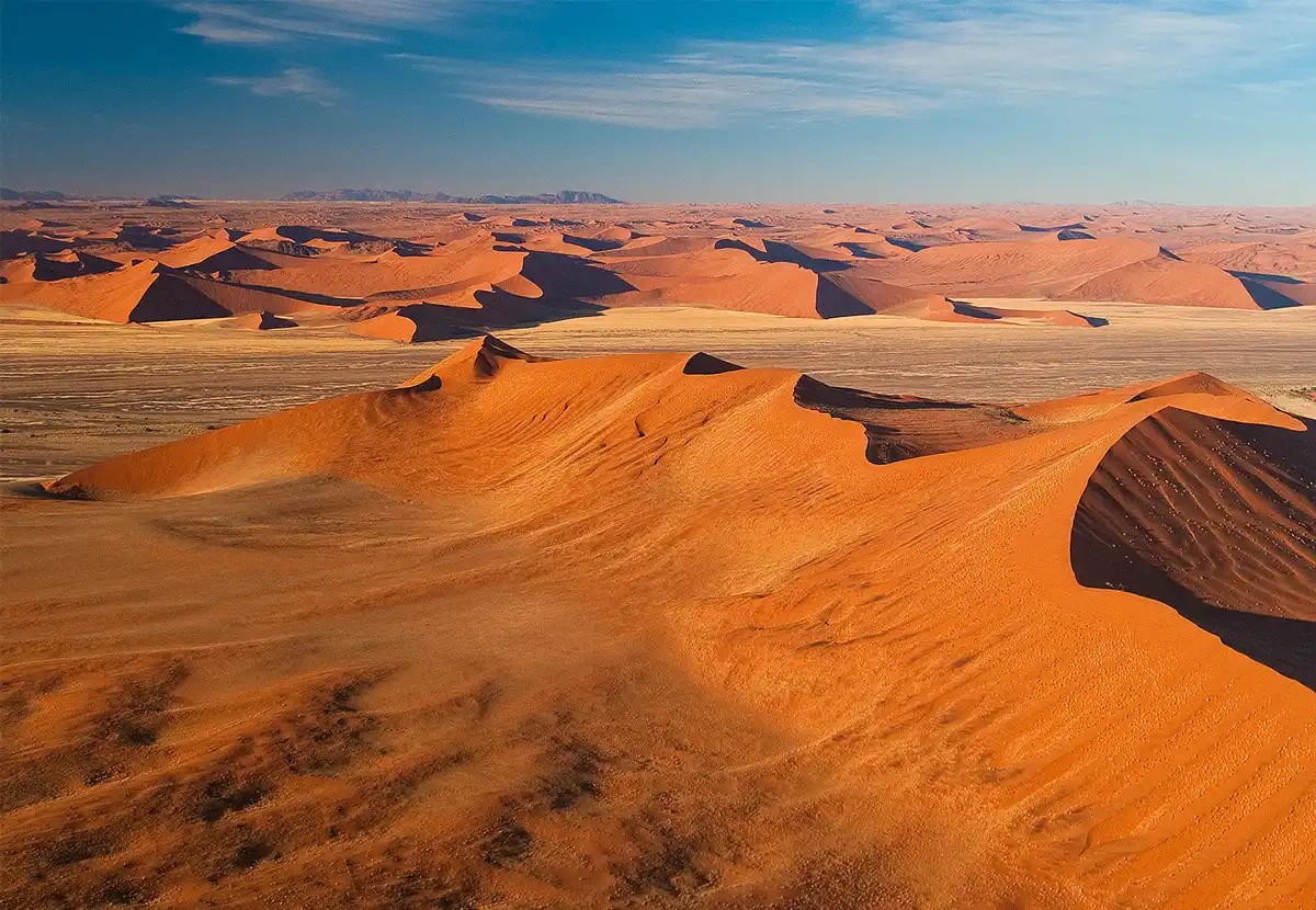 Sossusvlei Namibia tourism attraction: Endless sea of rust-red dunes with oryx.