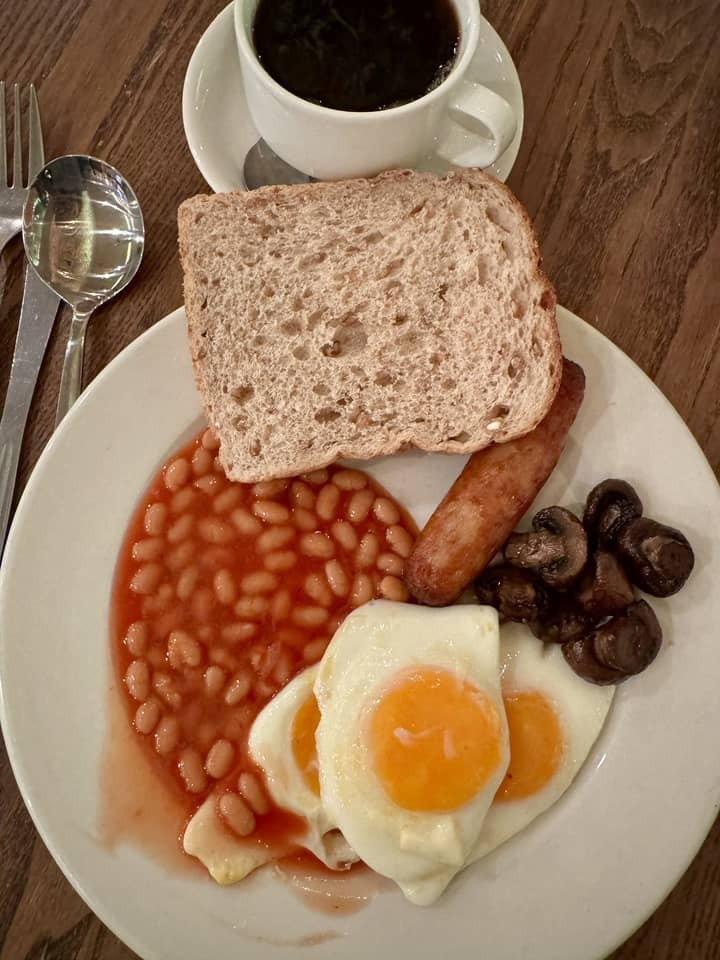 A traditional Irish breakfast featuring beans, eggs, toast, and sausage on a plate, presenting a hearty start to the day and a taste of Irish culinary traditions.