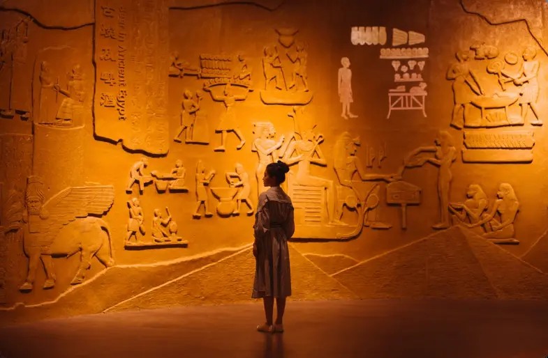Woman viewing hieroglyphic wall