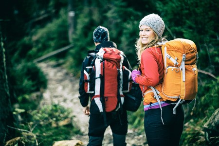 woman and man hiking with backpacks