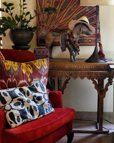 Living room corner featuring a vintage Rajasthani water stand and Moroccan zouaq ceiling panel, embodying the India World Traveler Collection's global-inspired decor