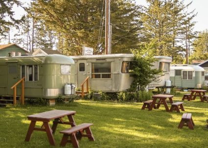 Exterior view of a fully restored vintage travel trailer, showcasing its classic design and polished finish