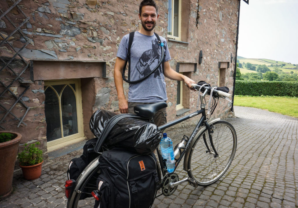 The author with a scrapyard touring bike costing £10 and a set of donated luggage.