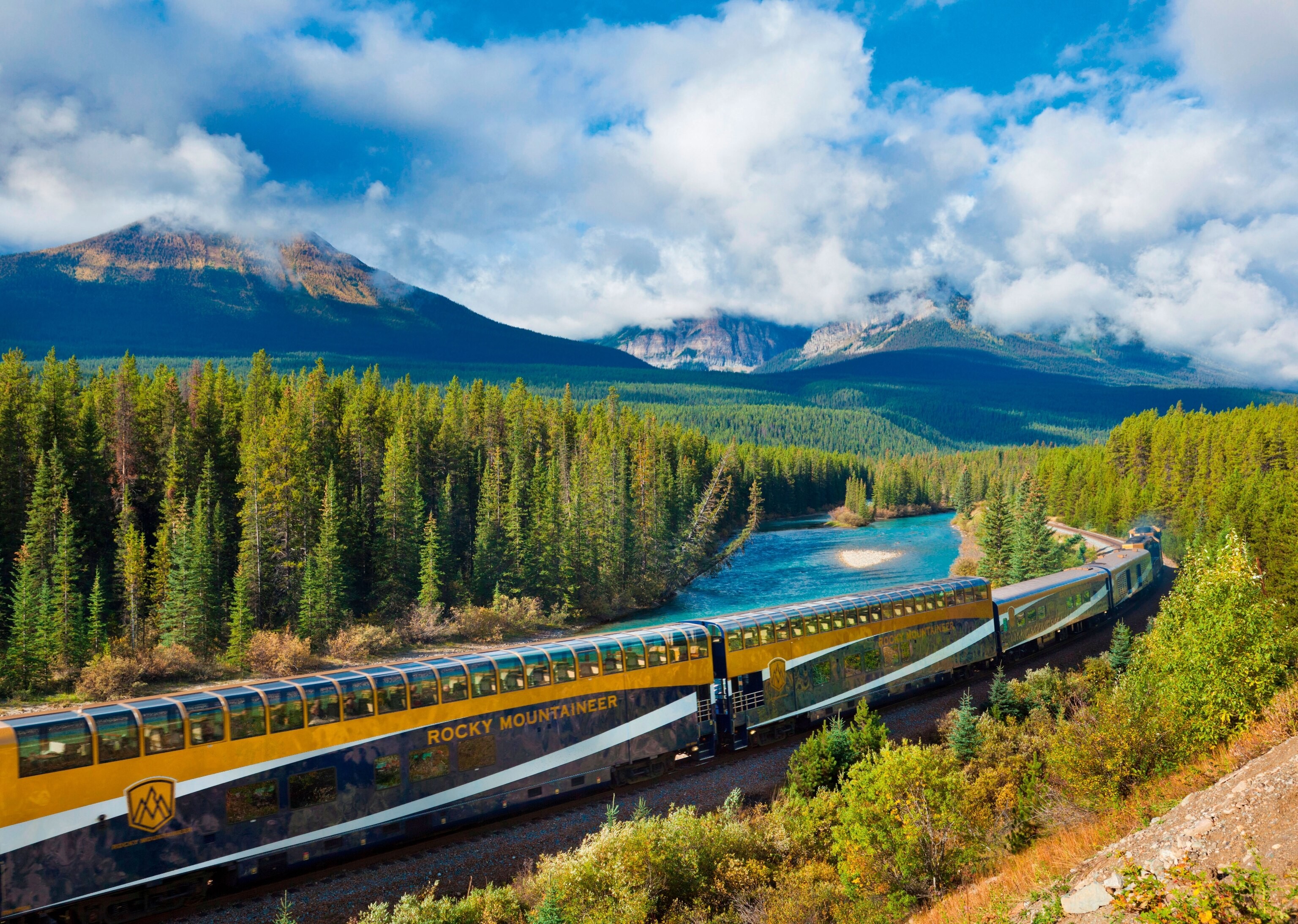 train curving near Lake Louise on bright, sunny day