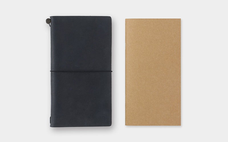 A collection of traveler's notebooks in various sizes and colors, along with pens, charms, and other accessories