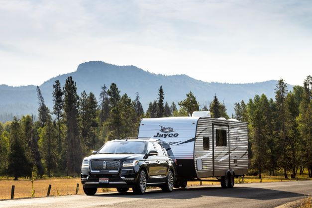 A truck pulling a Jayco Jay Flight travel trailer, illustrating the downward price trend in 2025