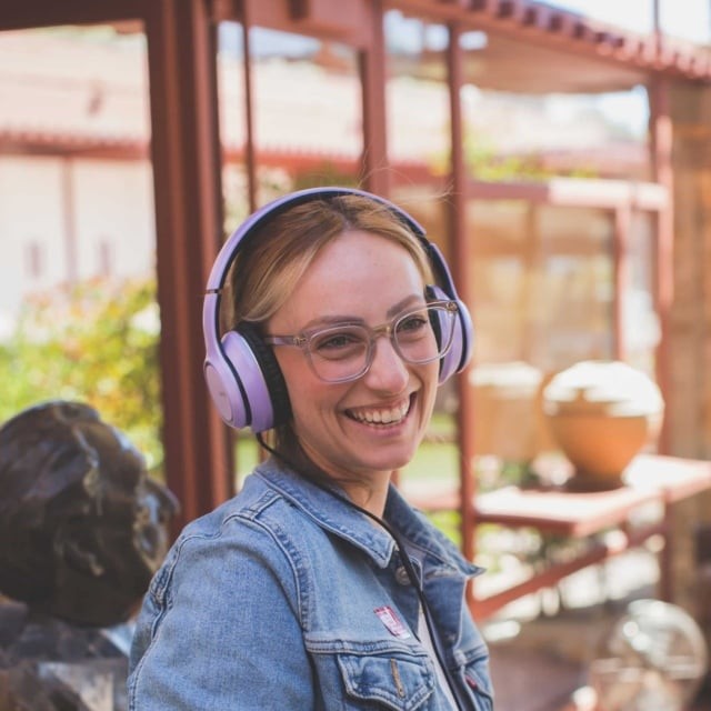 A visitor on the Self-Guided Audio Tour, wearing headphones, stands in the Garden Room at Taliesin West, learning about its history and Frank Lloyd Wright