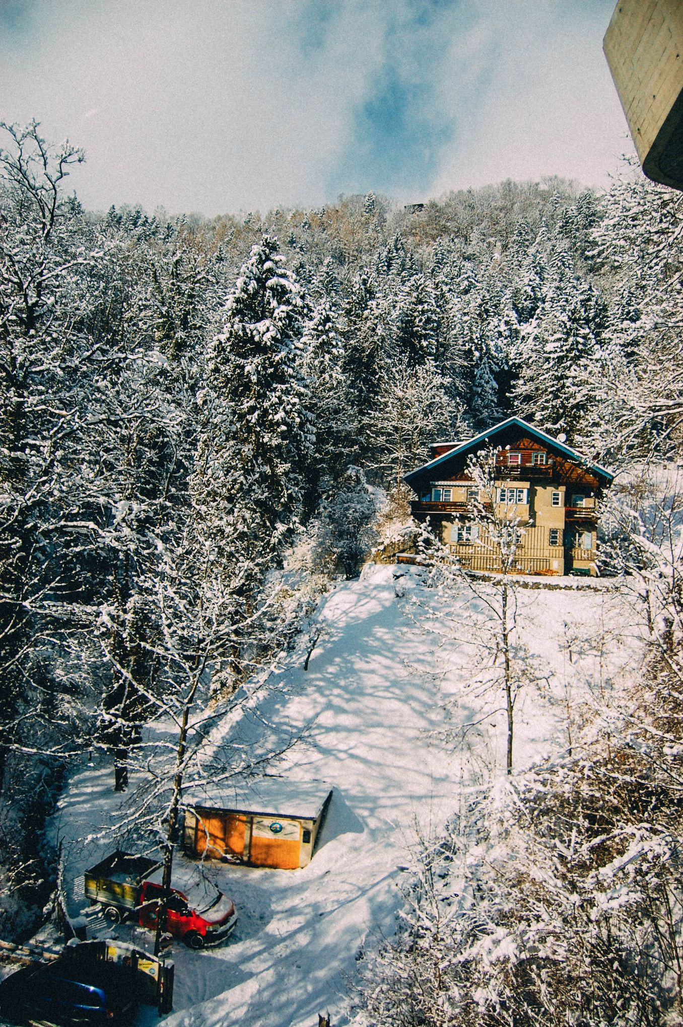A picturesque view of the Austrian Alps in winter, with snow-covered mountains, traditional houses, and a clear blue sky. The scene captures the peaceful and serene atmosphere of the region.