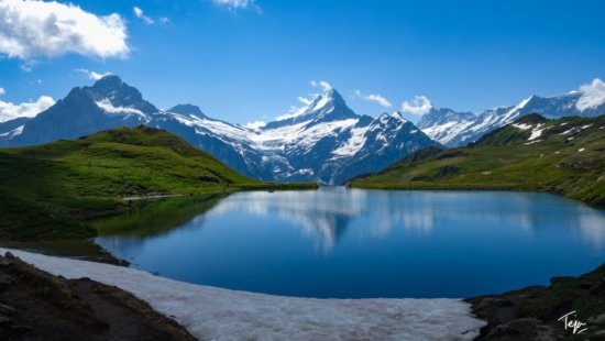 Hike to Bachalpsee Lake, a picturesque alpine lake known for its stunning reflections of the surrounding peaks