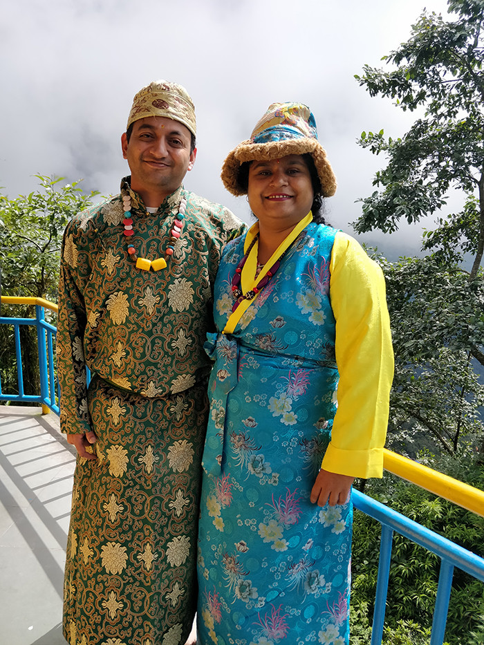 Dress up in local clothes at Ganesh Tok Alt Text: Tourists dressed in traditional Sikkimese attire at Ganesh Tok, enhancing their cultural experience and providing memorable photo opportunities against the backdrop of scenic landscapes.