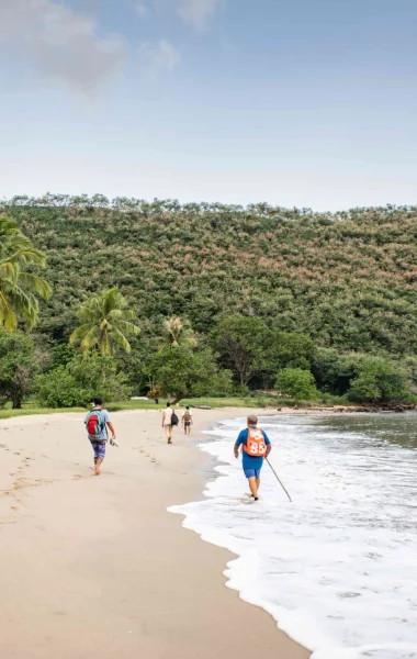 Walking along Nuku Hiva's white sand beach offering a serene coastal experience