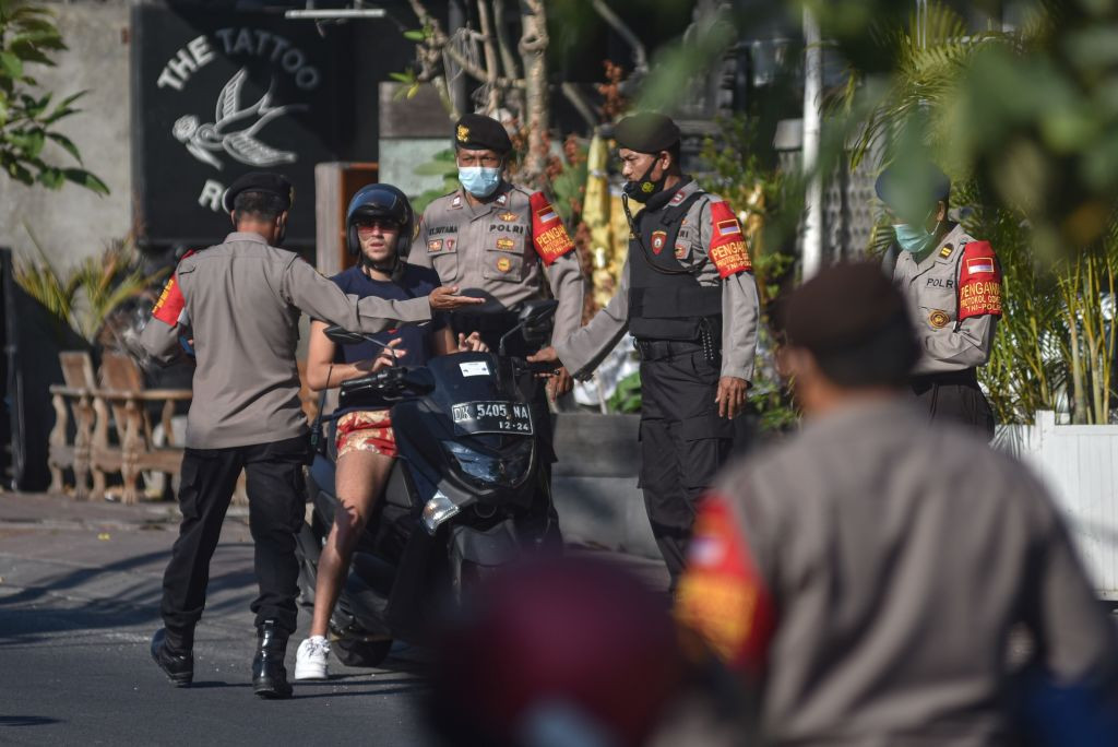 Police officers in Bali monitoring tourist activities to ensure compliance with local regulations.