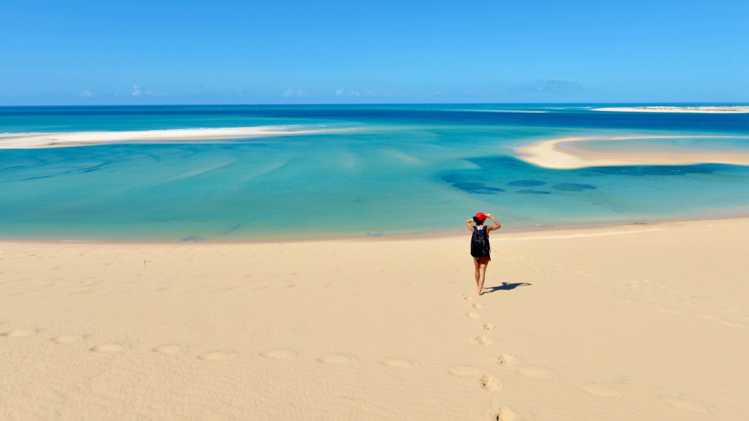 A woman has walked down the soft golden sand to the Atlantic waterfront of one of Mozambique