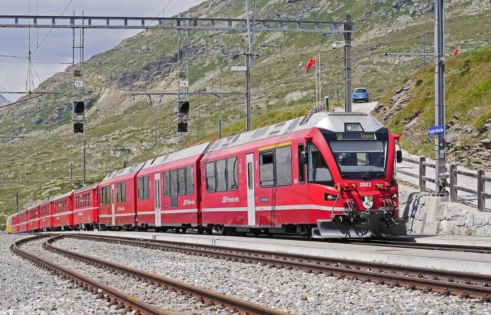 A train traveling through the scenic Bernina Railway, showcasing the beauty and accessibility of train travel in Europe.