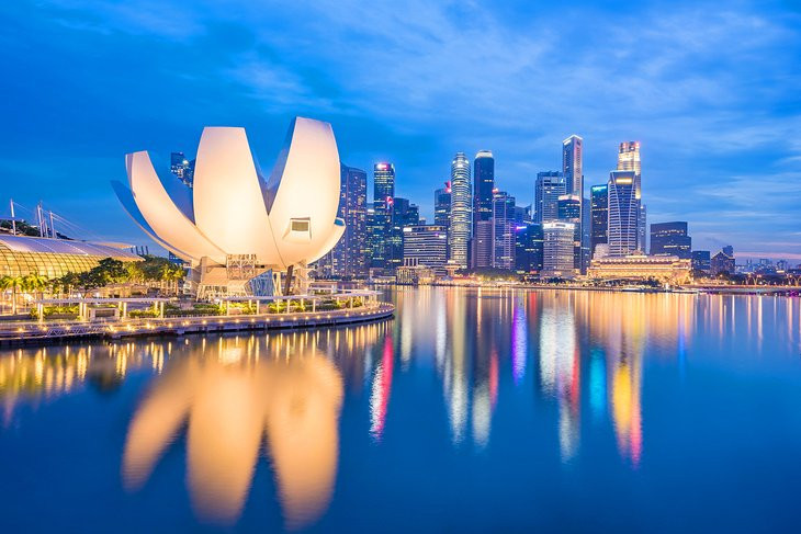 Marina Bay in Singapore at dusk, featuring stunning city lights and waterfront views