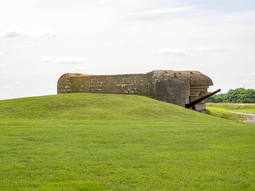 old brown gun installment surrounded by green grass