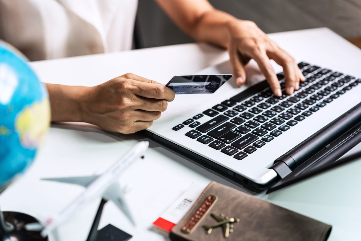 person on laptop with credit card in hand.