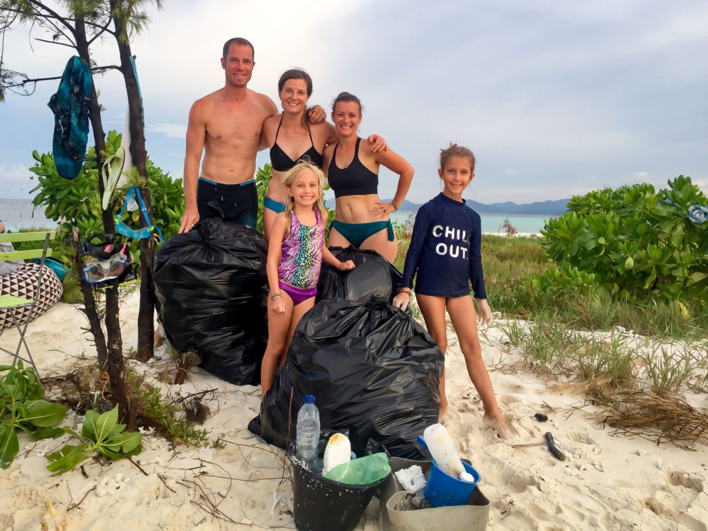 Three massive bags of garbage picked up from a small atoll in Indonesia, showcasing the plastic waste that washes up from the ocean, highlighting the environmental impact of single-use plastics and the importance of reducing plastic waste while traveling.