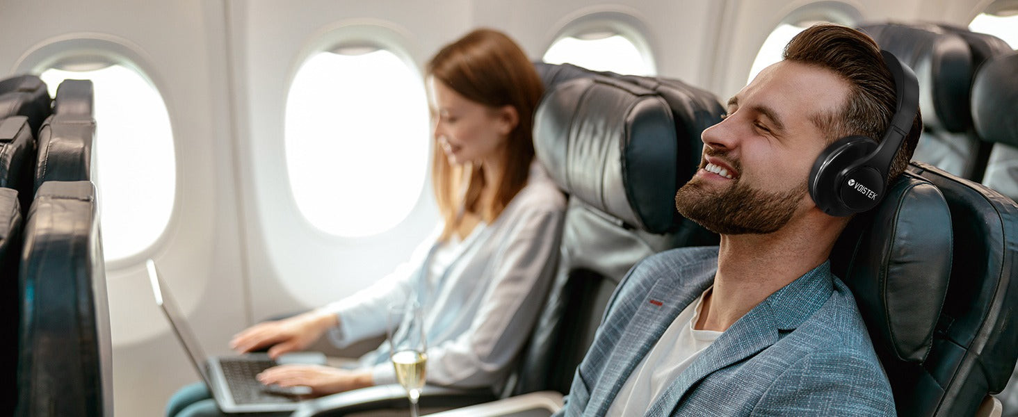 Woman wearing noise cancelling headphones on a plane, enjoying the quiet