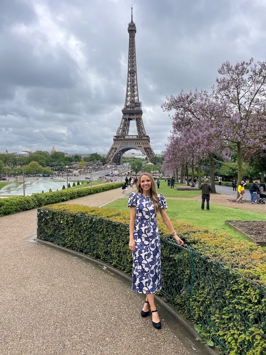 Woman in black dress in front of Eiffel Tower