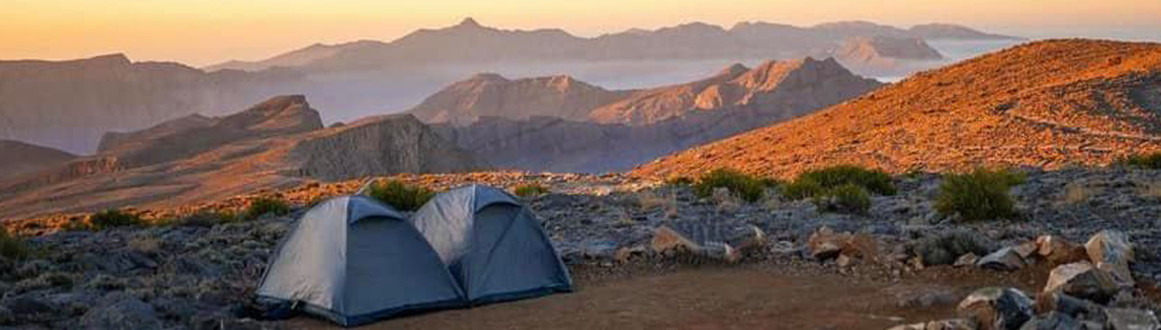 Campsite tent in the mountains at sunset