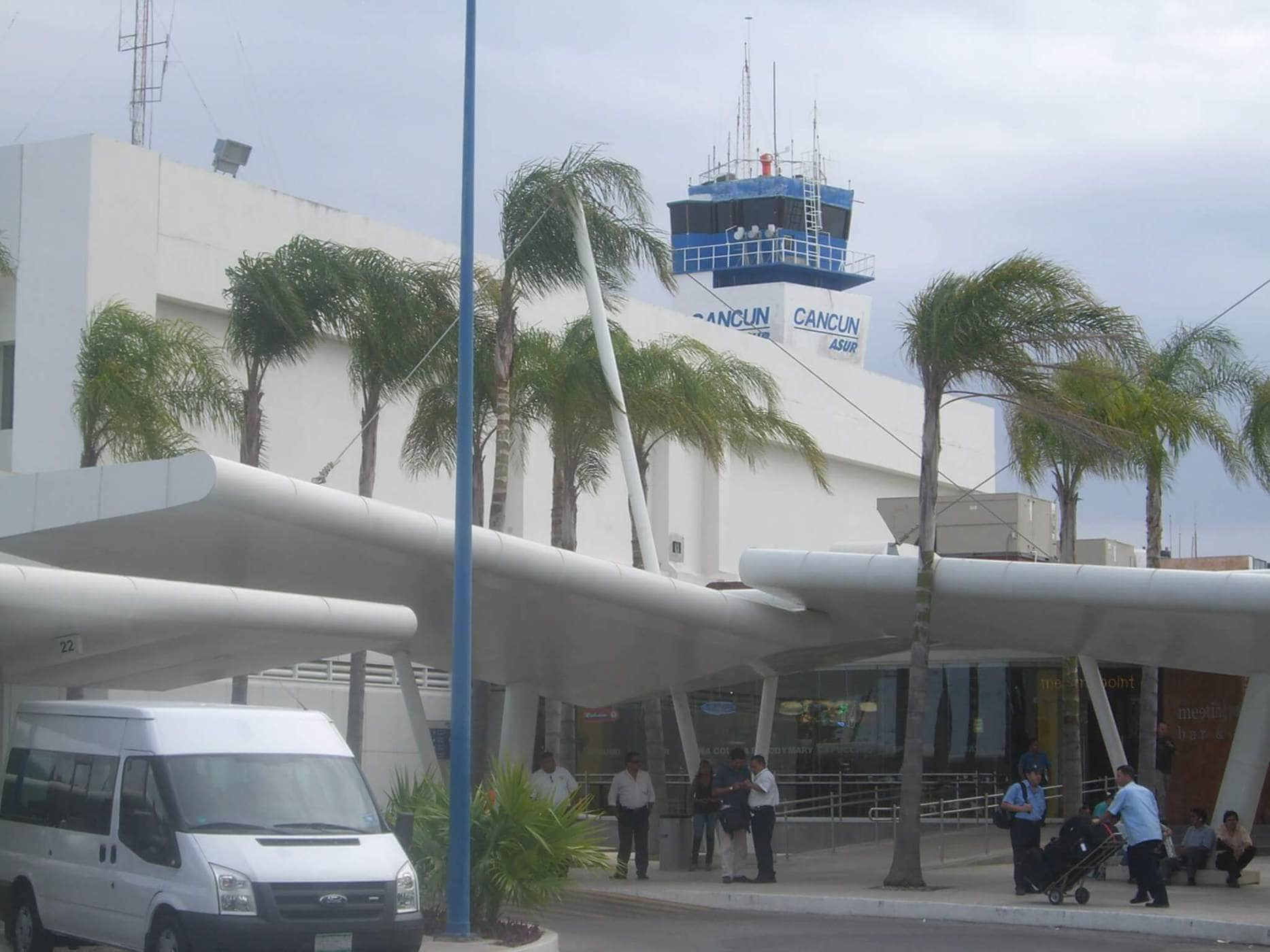 Outside Cancun Airport featuring shuttle buses, a common mode of transport to Tulum