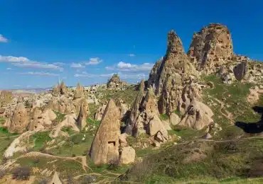 Hot air balloons flying over Cappadocia's unique landscape, creating a scenic aerial view.