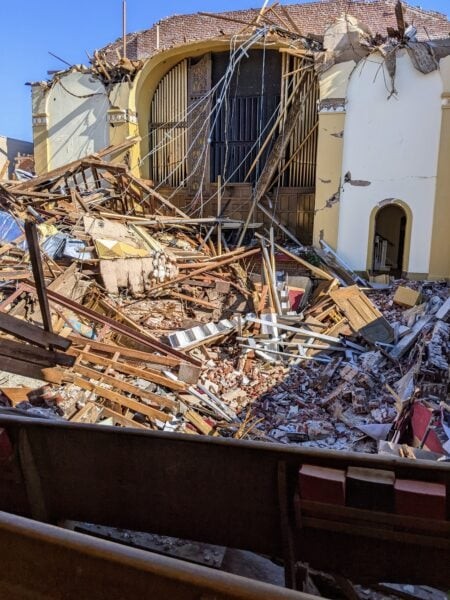 Rubble aftermath of an earthquake in a city, highlighting the need for travel insurance
